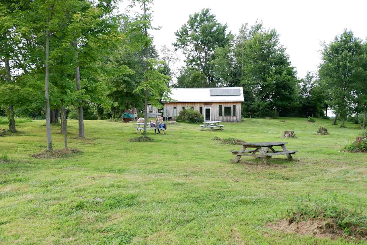 The cabin is close to the pond and has three picnic tables to eat at