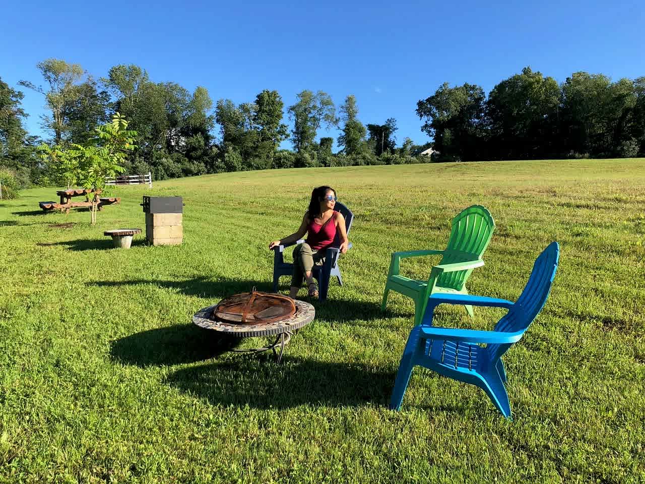 Great Site setup with fire ring, chairs, a grill, and a beautifully made log bench.