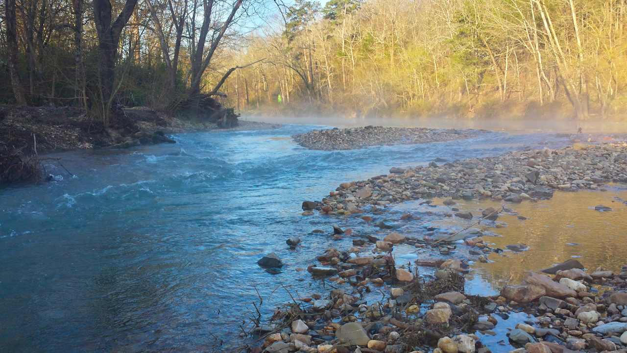 This is the view of the river looking upstream from the rock beach. A green kayak is visible in the distance at the base of our deck stairs.
