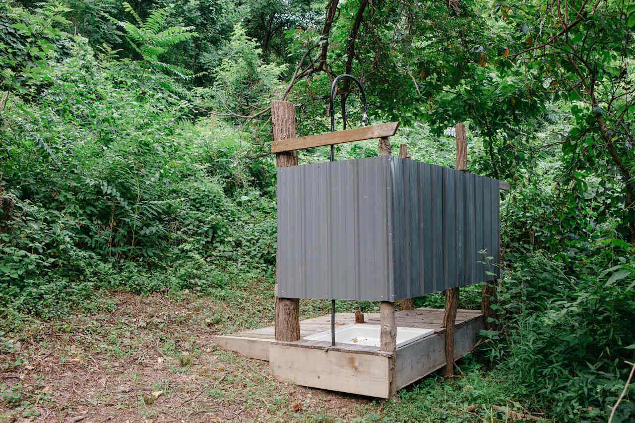 The outdoor shower, just past the garden on the hill above the circular shelter. 