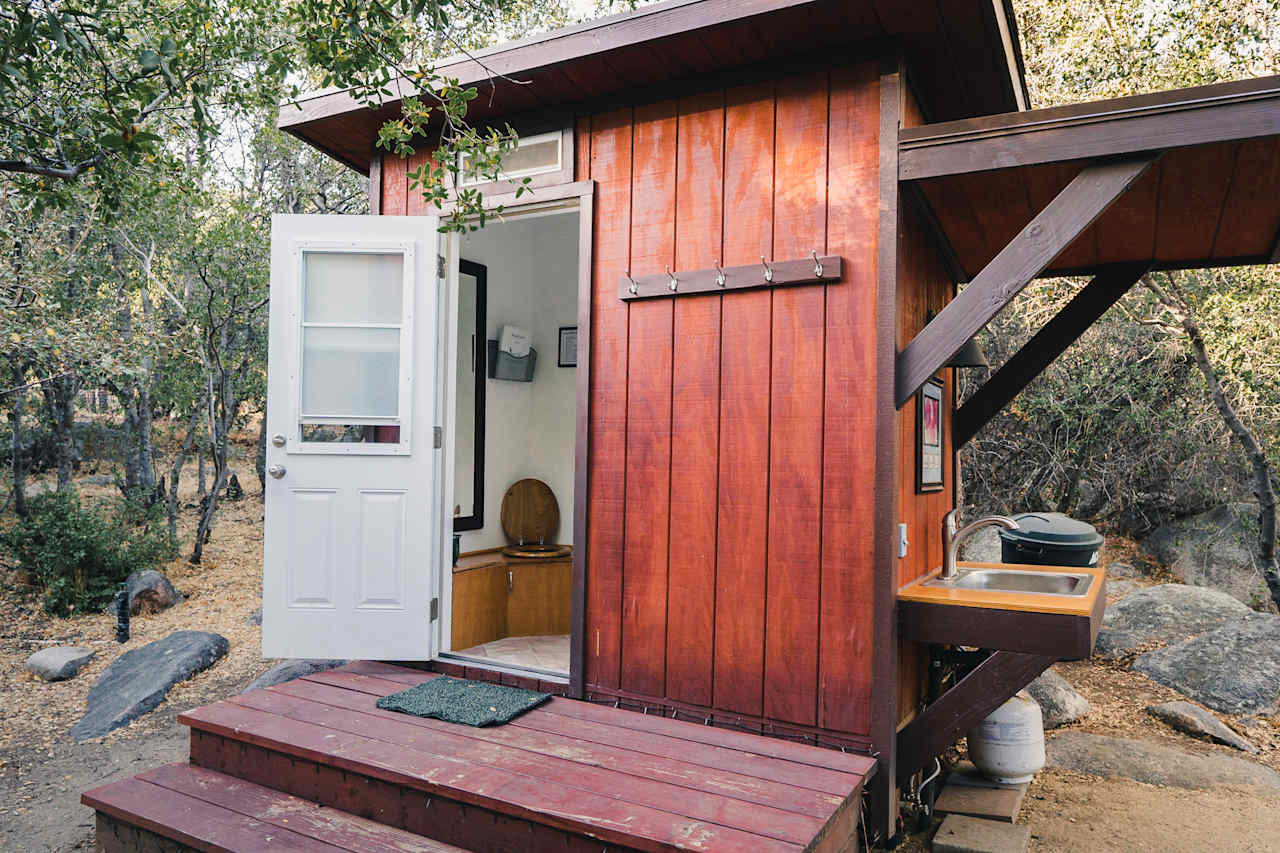 Composting toilet with a warm water shower inside