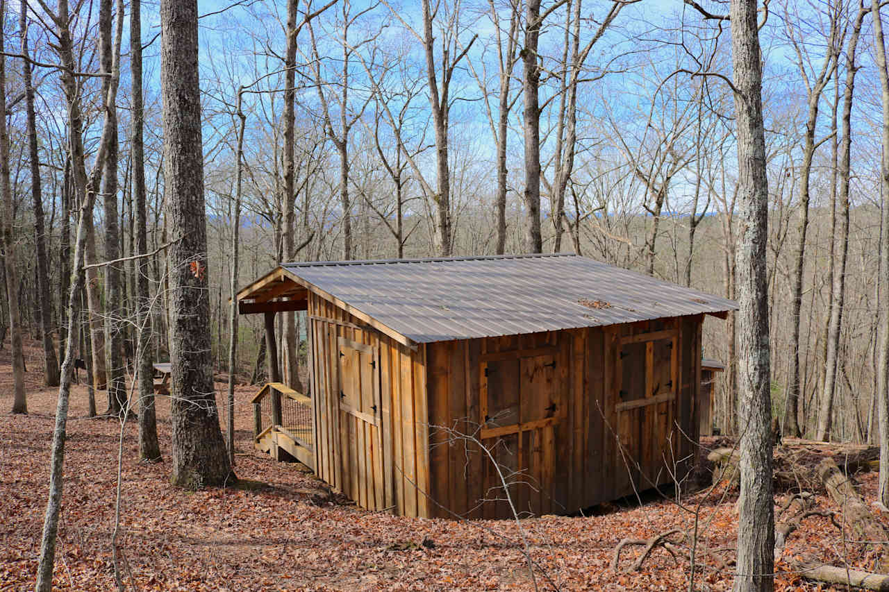 the Mountaintop shelter is nestled in the hillside and has four big windows with storm shutters