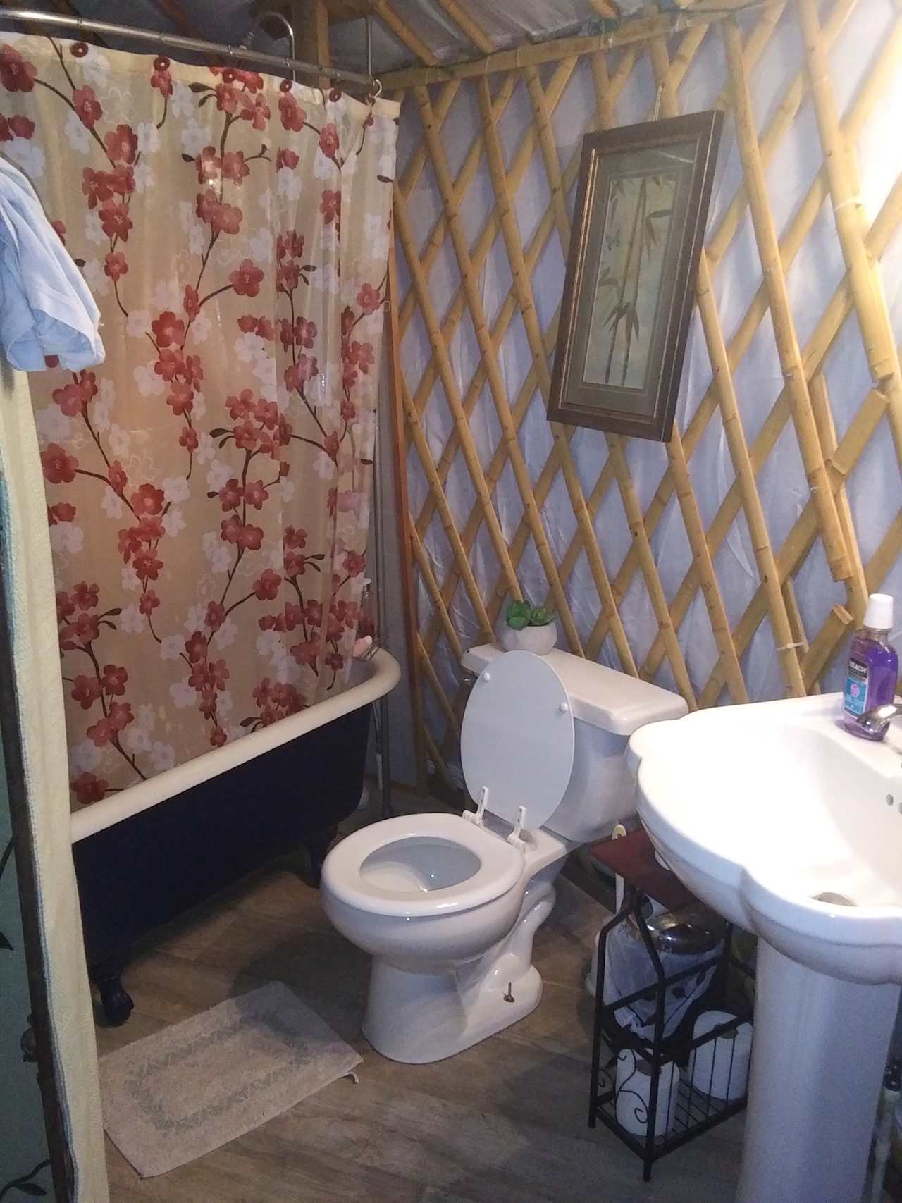 Beautiful claw foot tub, bathroom partially separated by 2 screens.