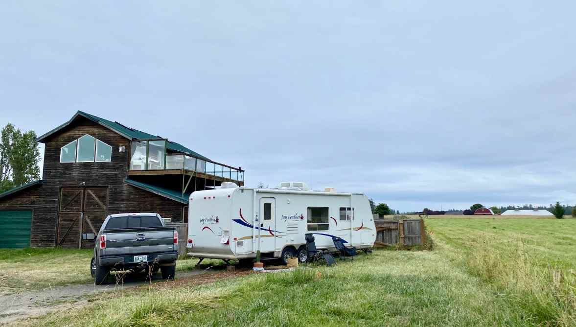 Camper pad is between Sid's home and a large field.