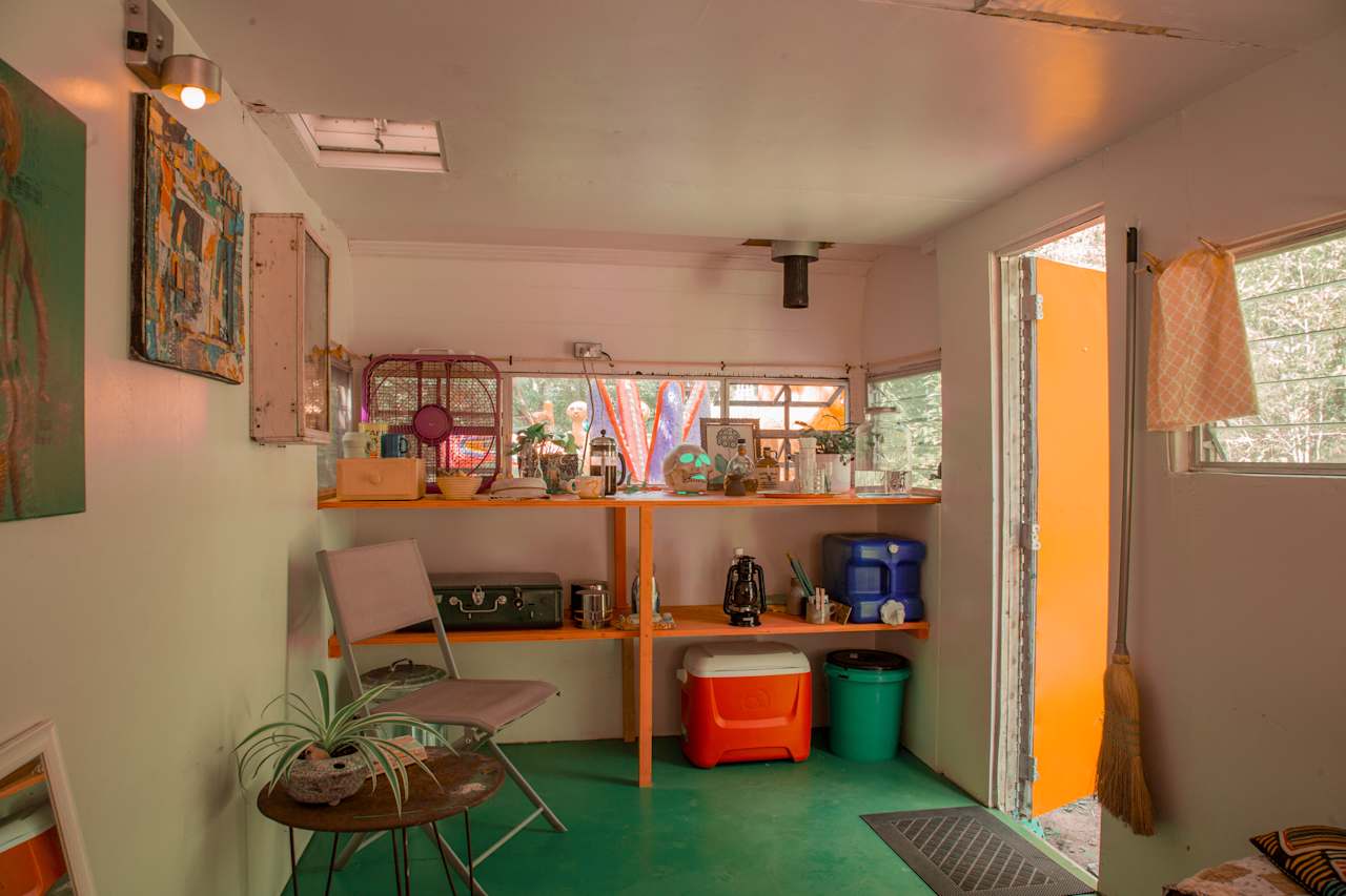 At the front of the camper you will find a countertop and shelves.  Here you will find everything for eating, drinking, cooking and washing up.  See on the right the big blue water jug and bucket below, this will be your "sink"