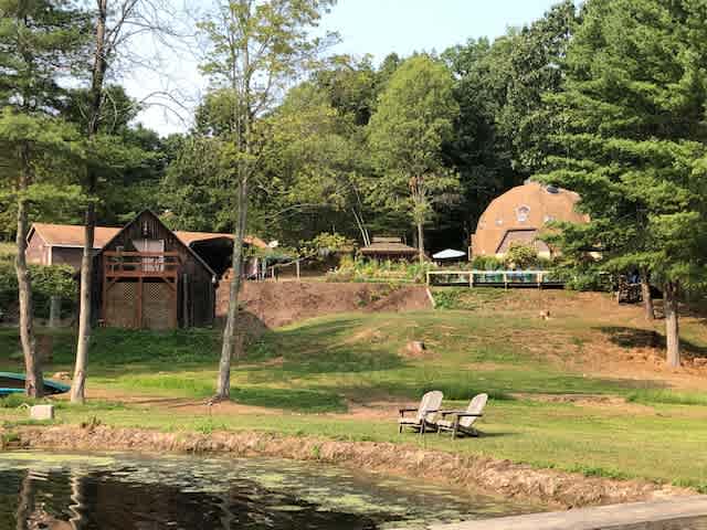 View from the pond of domehouse, greenhouse, barn and garage...