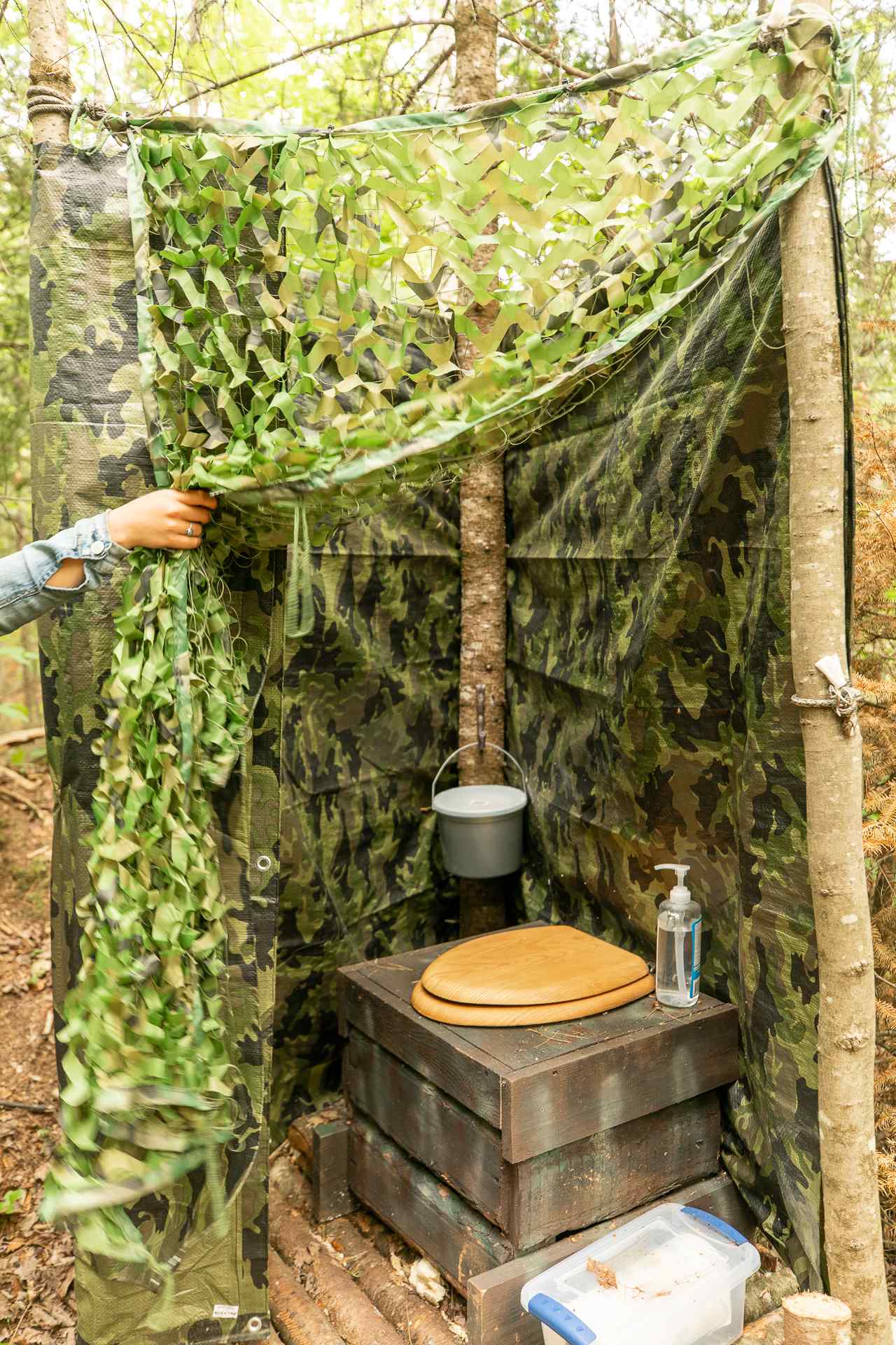 Outhouse with stocked TP and hand sanitizer.