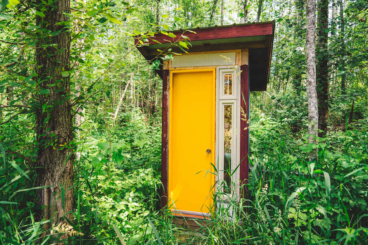 The flush outhouse with running water located near the field at the front of the property. 