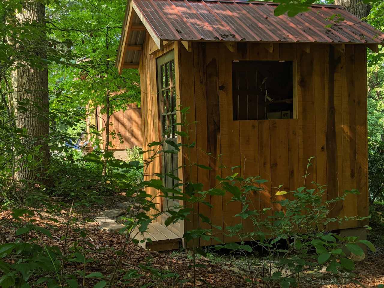 View of the outhouse with the barn just behind it.