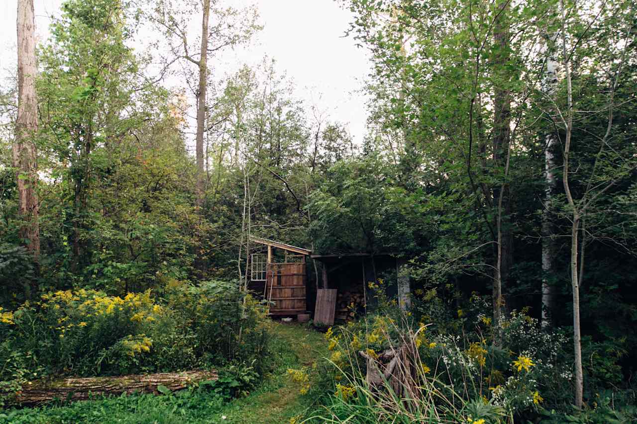 A wood shed and an outhouse.