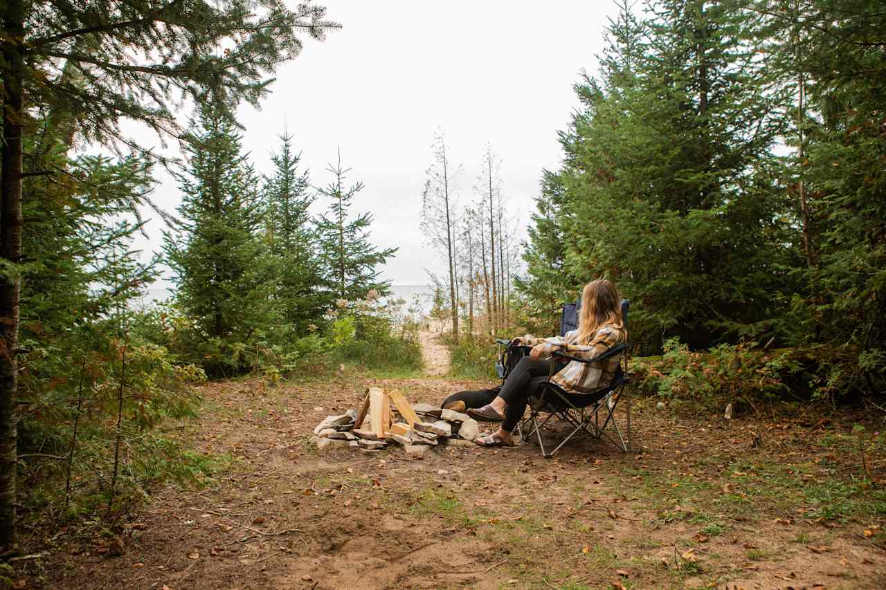 There is a clearing in between the wooded area and the beach that has a firepit and plenty of room for a tent.