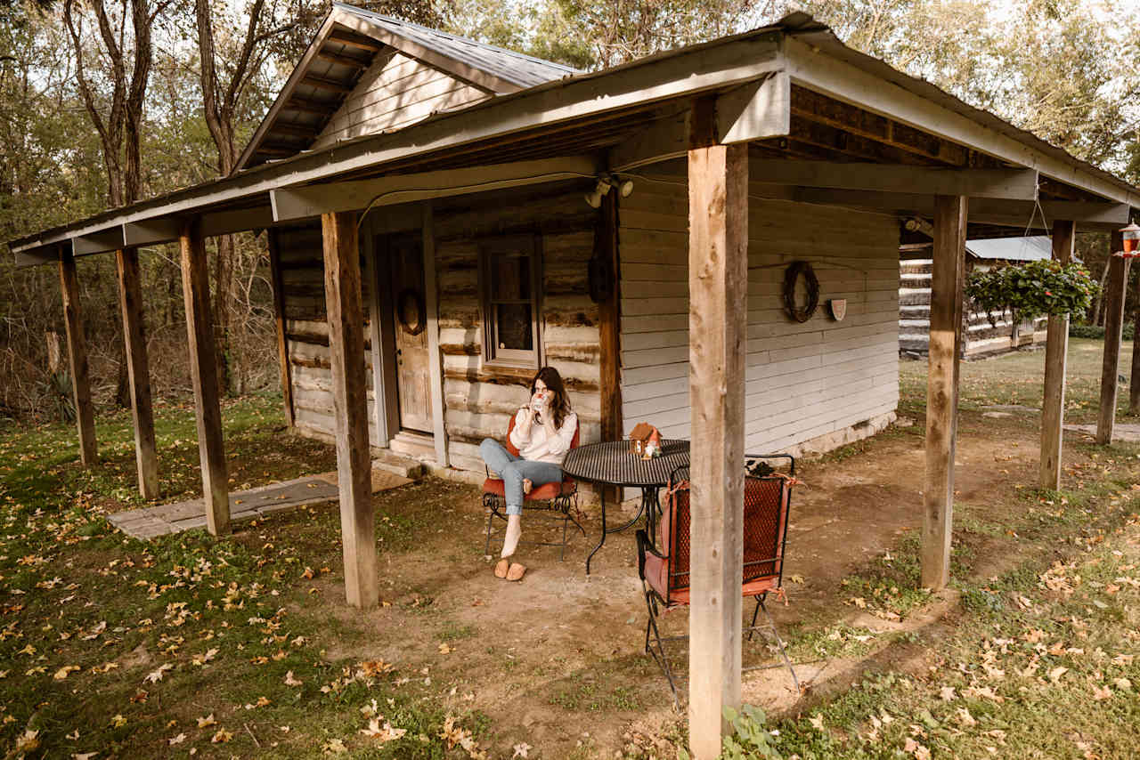 There’s a patio table and chairs set up outside of the cabin.