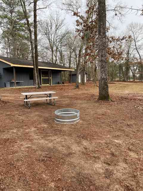 Campsite in front of bathrooms fire pit and table