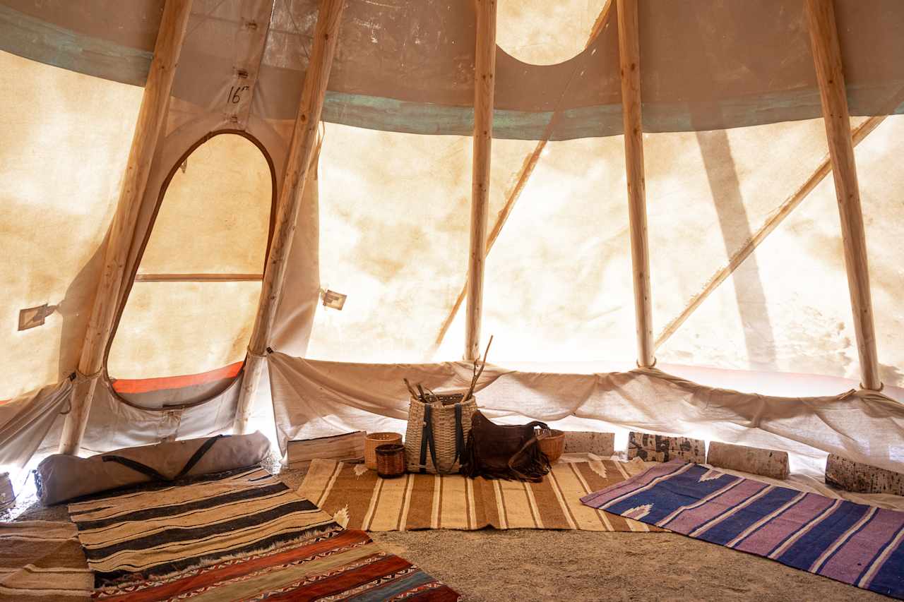 The inside of the teepee is beautifully decorated with woven baskets and rugs.