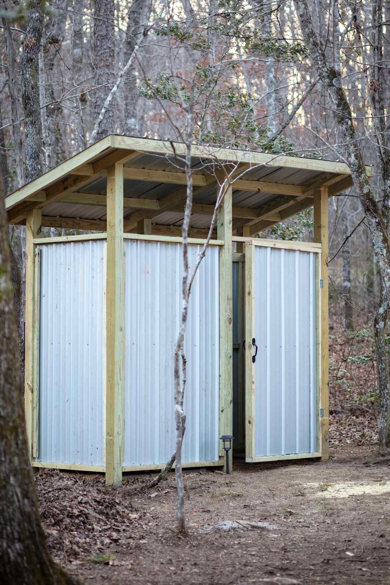 Wash house with solar shower and composting toilet.