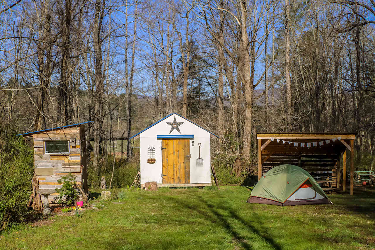 The outhouse, work shed, our tent, and the outdoor kitchen