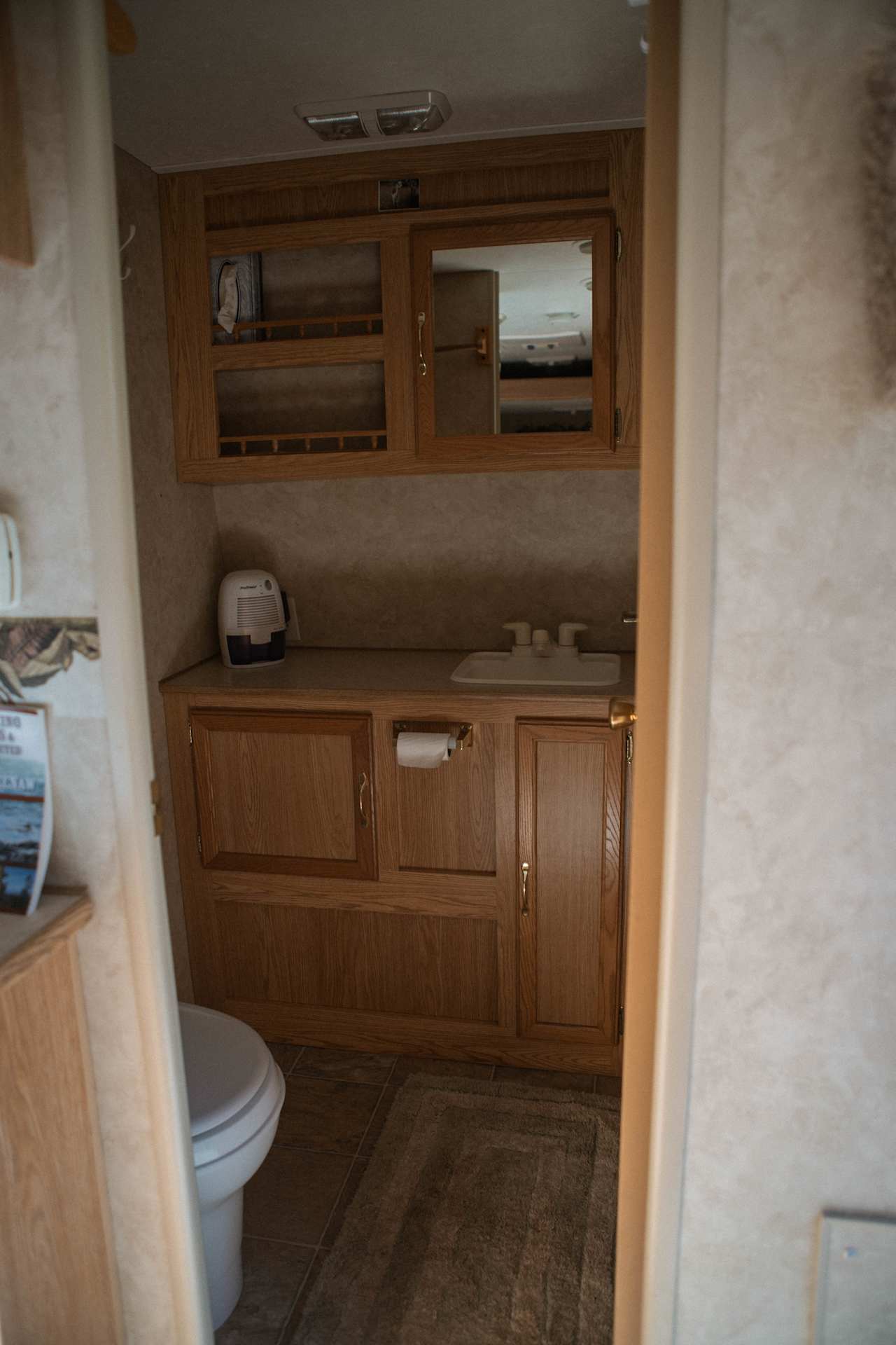 The bathroom has a small sink counter and toilet. 