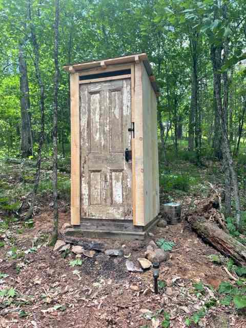 The second outhouse closer to the lake.