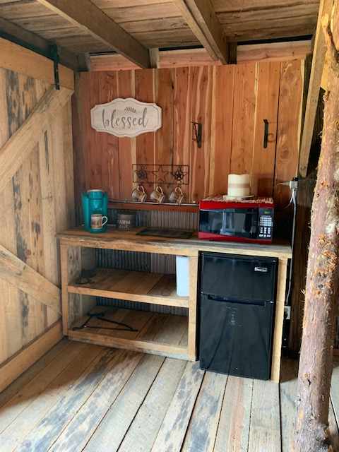 Kitchen area has microwave, fridge, and coffee pot.