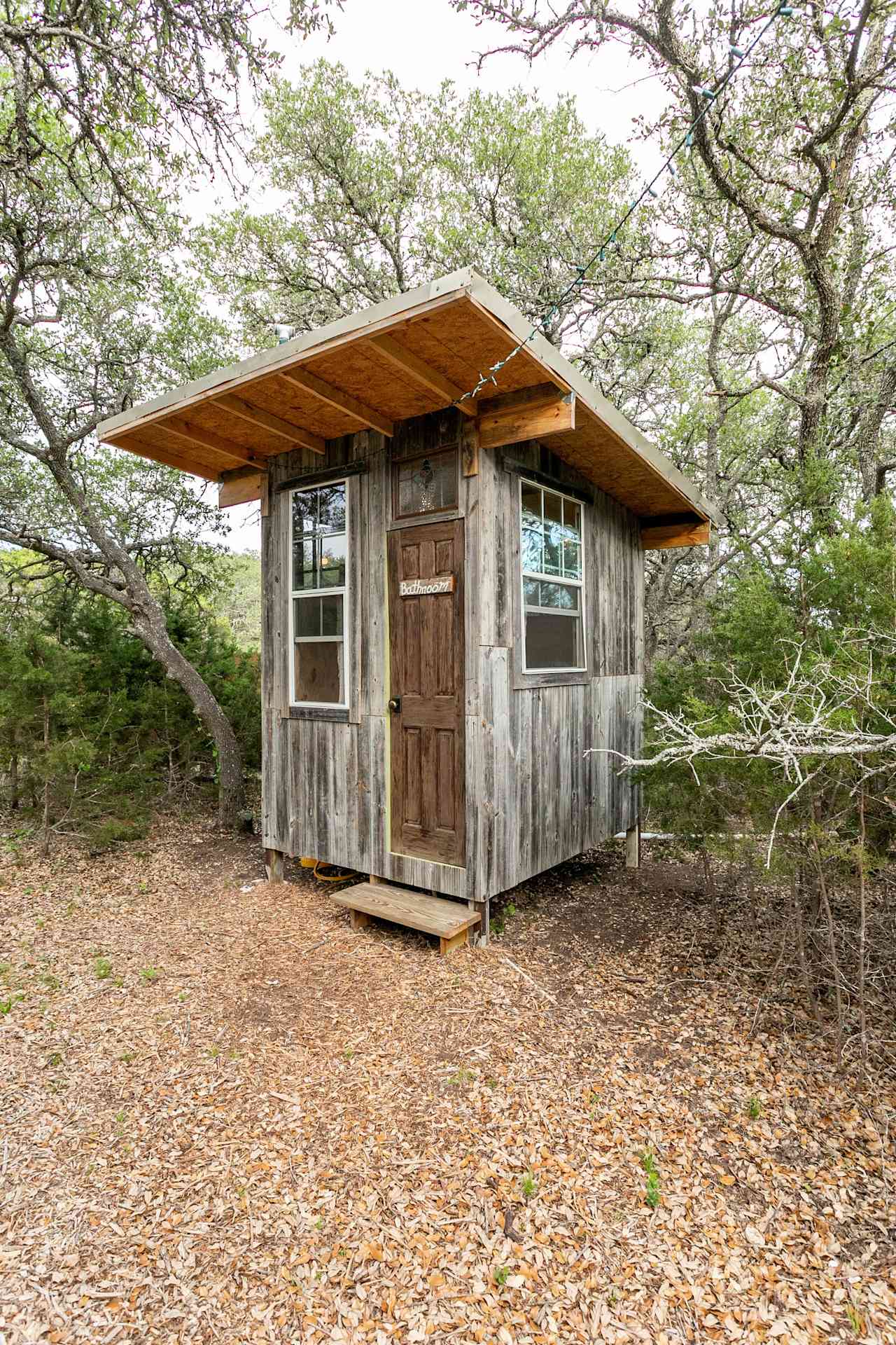 The "outhouse" is made from reclaimed fence wood! There's a composting toilet, sink, and shower. 