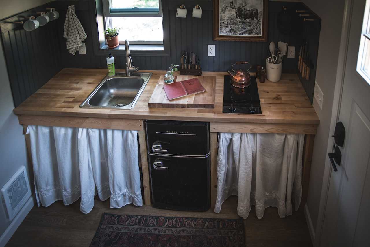 Kitchen with mini fridge, sink and stove top