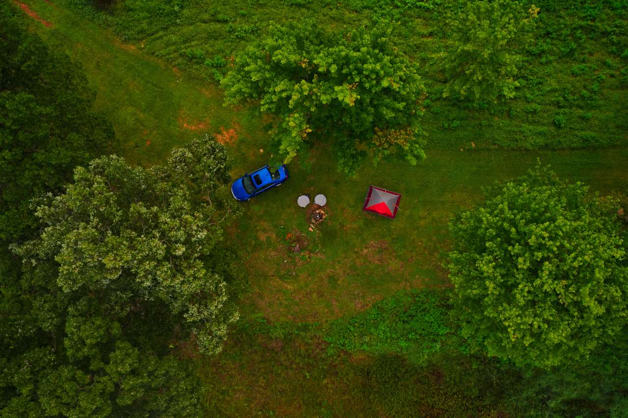 Above the trees looking down at Campsite C, Firepit and space for 2-3 large tents.