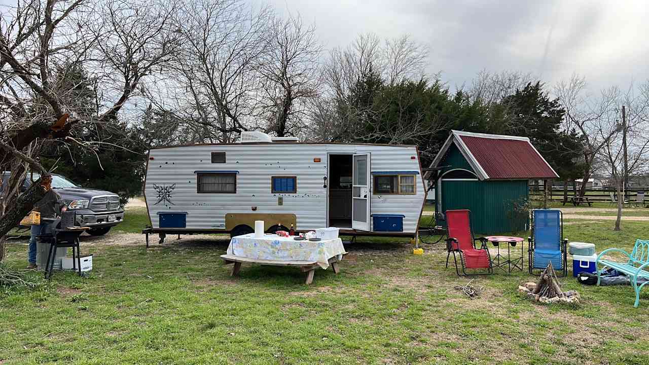 Clean grill, secure trash can, sturdy table in good repair, comfy bench, and fire ring. You can see one of the privies to the right of our trailer. 