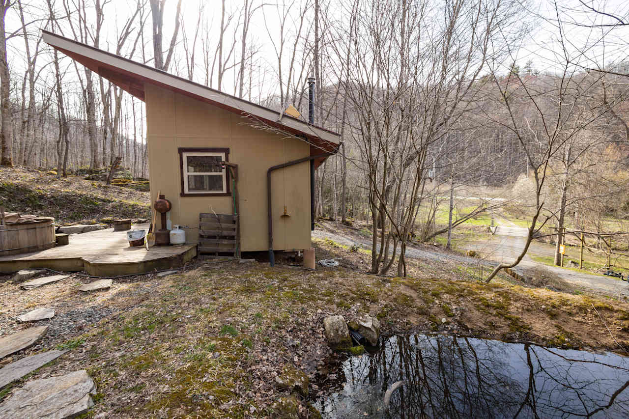 There is a small pond beside the tiny home.