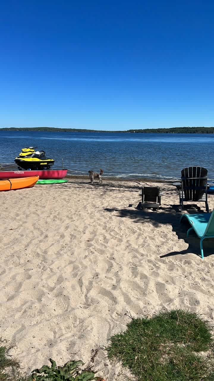 Sandy beach area with shallow water and water toys to us