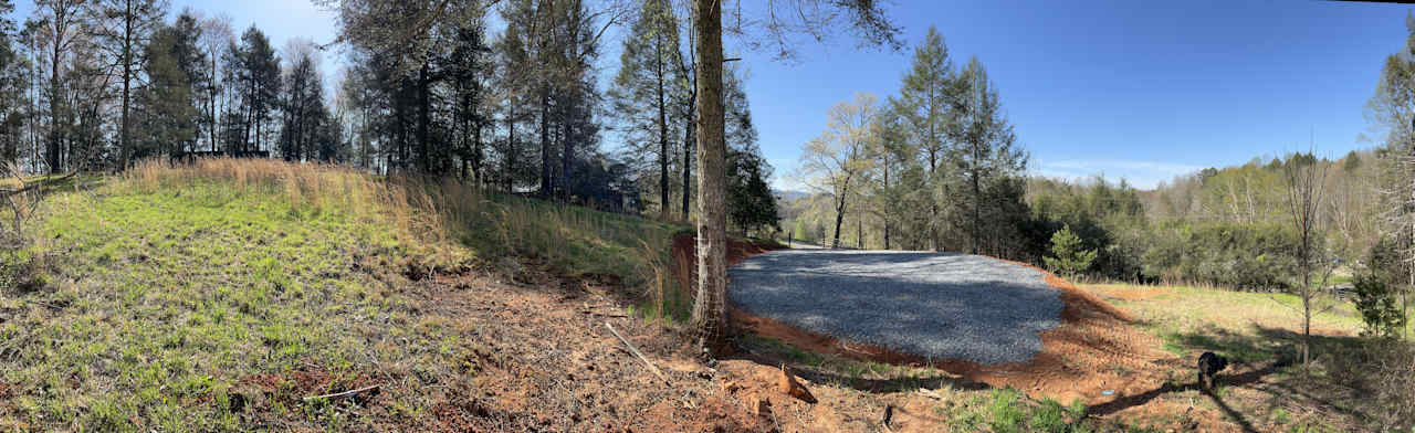 A panorama showing a bit of the hillside and tree line and your parking pad