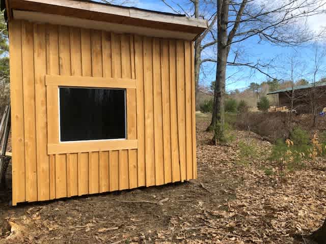 View from the other side of the cabin showing the picture window that looks into the woods