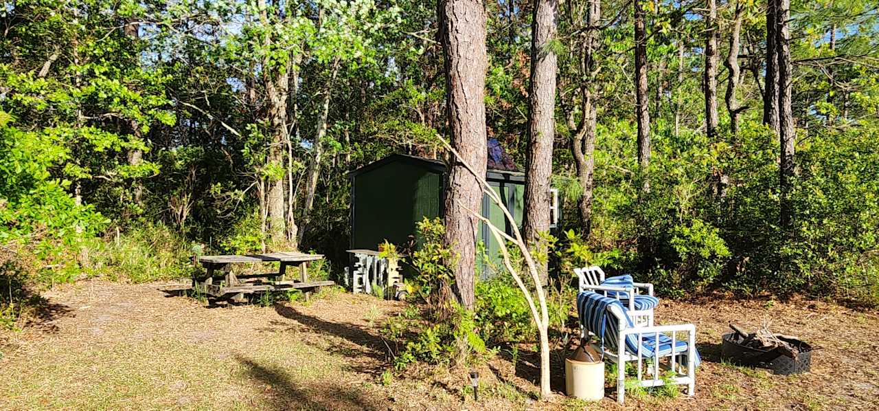 Picnic table prep table behind Trehaus..In-between the trees you can spot the second set of doors that can be opened to wake up looking at the pond from the bed