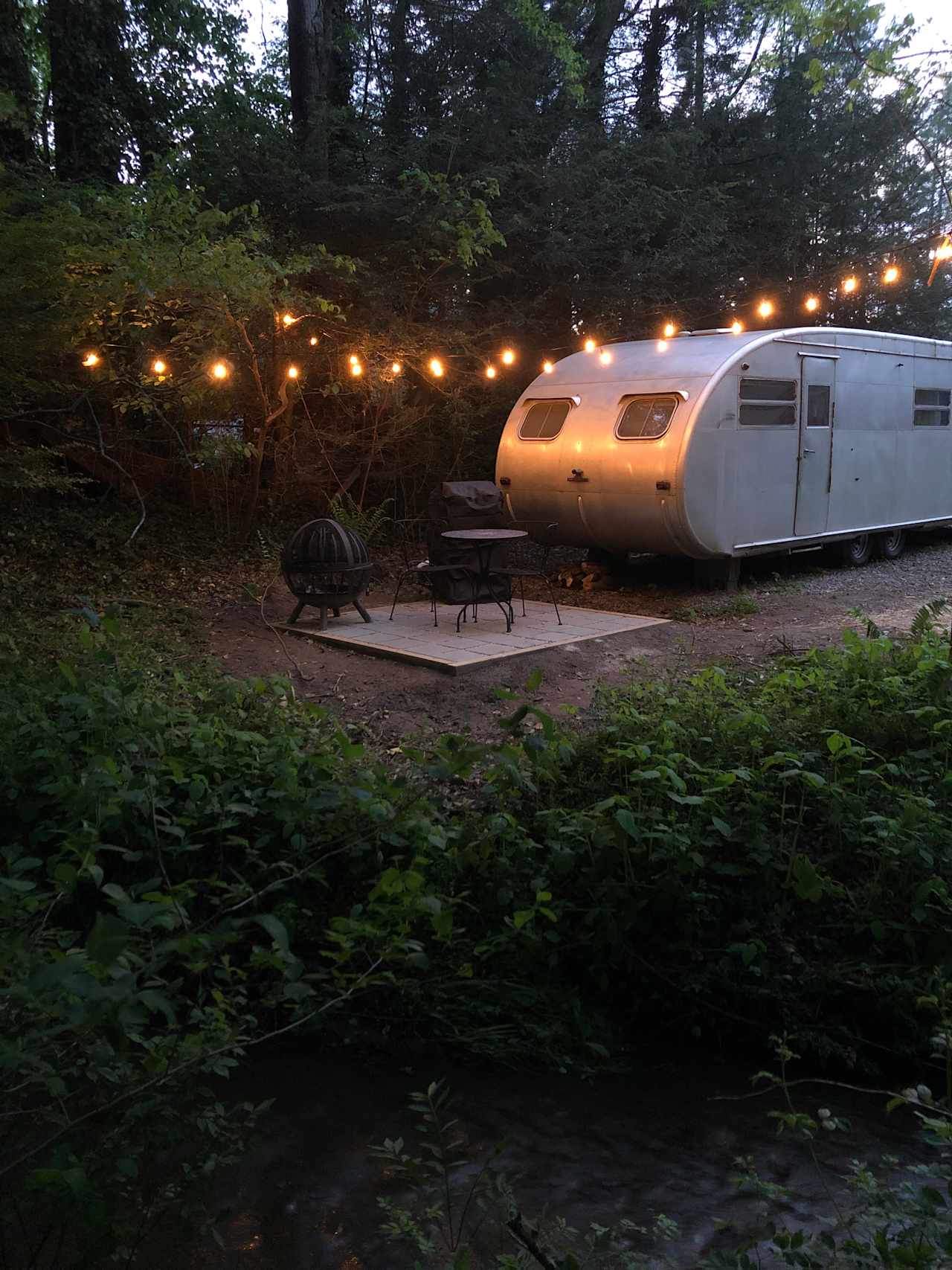 Your private patio with magical lighting, grill and fire pit awaits! Notice the stream in the bottom of the image.