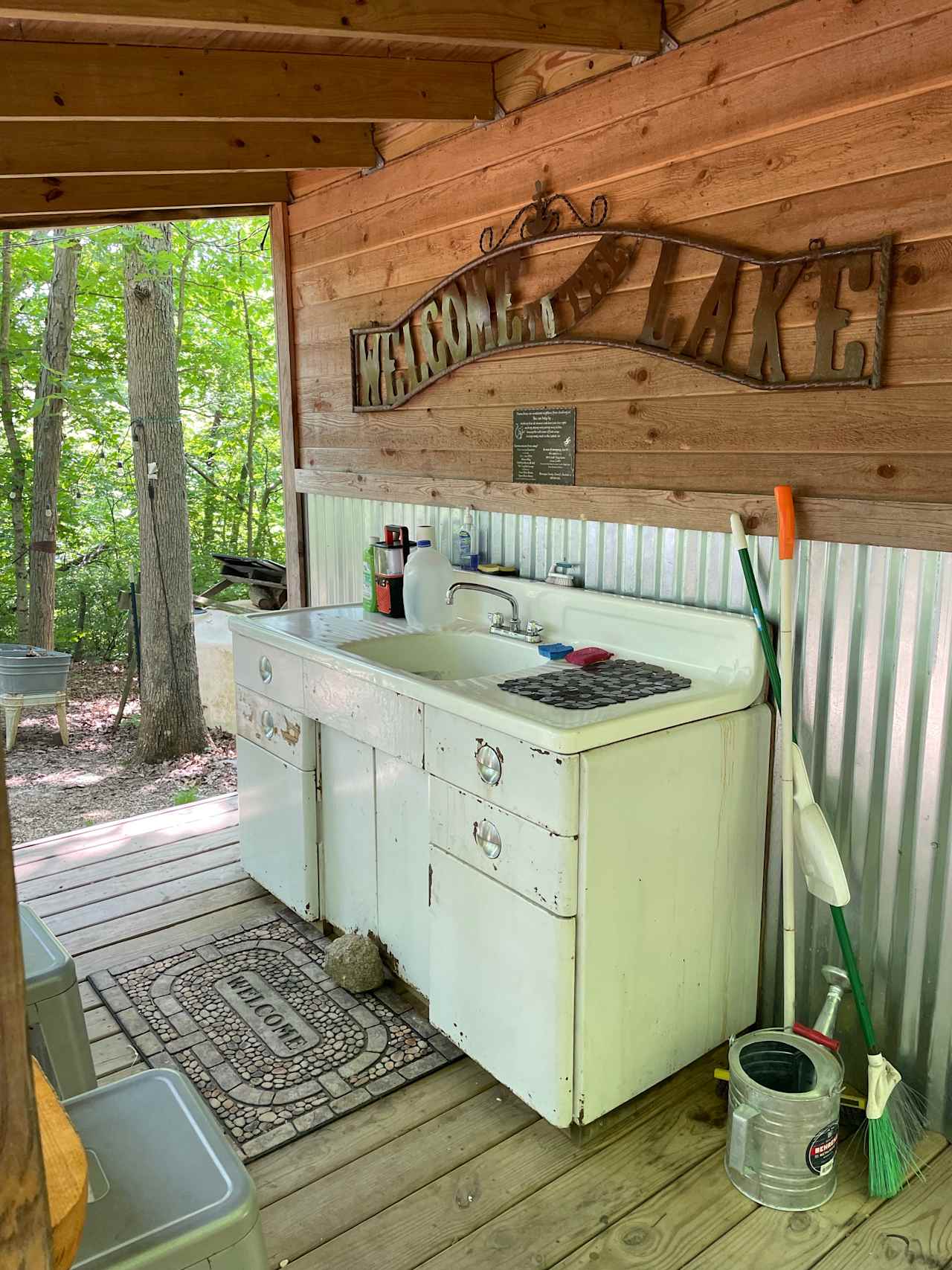 Kitchen area with running water and stocked with dishes and silverware. 