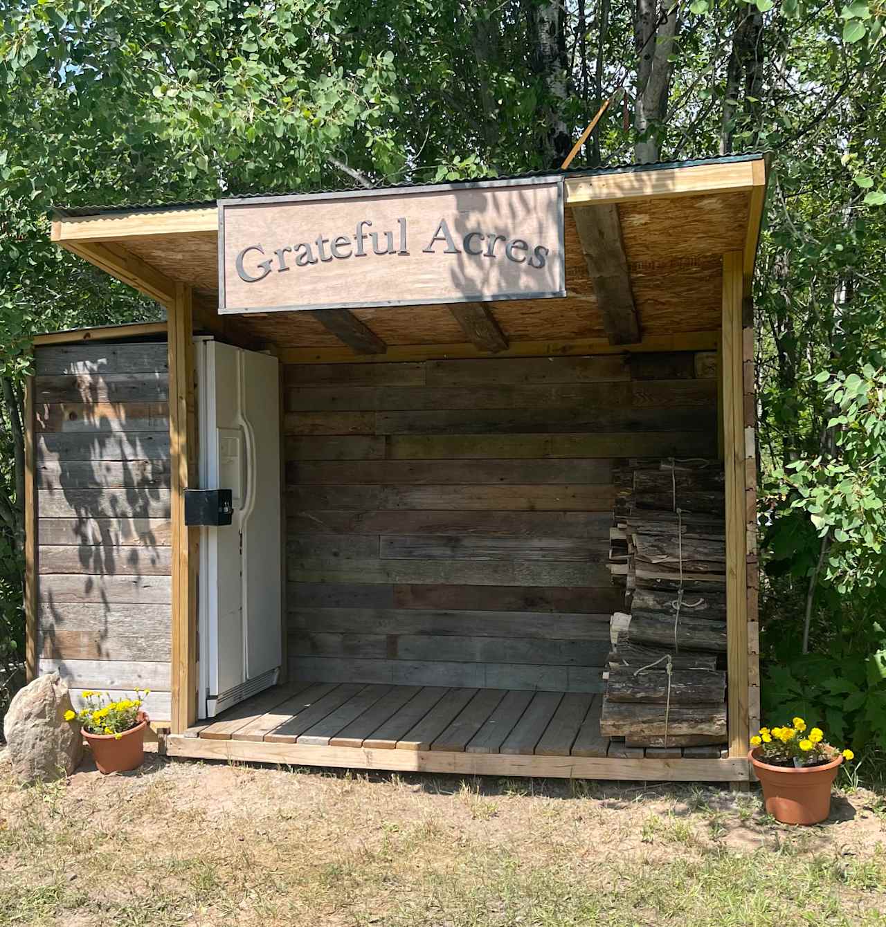 Grateful Acres Welcome Hut
 
 This is the welcome Hut. You will find at the top of the driveway upon entering the property. Notice the recent upgrade of a communal refrigerator and freezer for campers use. The refrigerator has one large shelf for each campsite. Also newly available within the refrigerator, are some small amenities available for purchase.