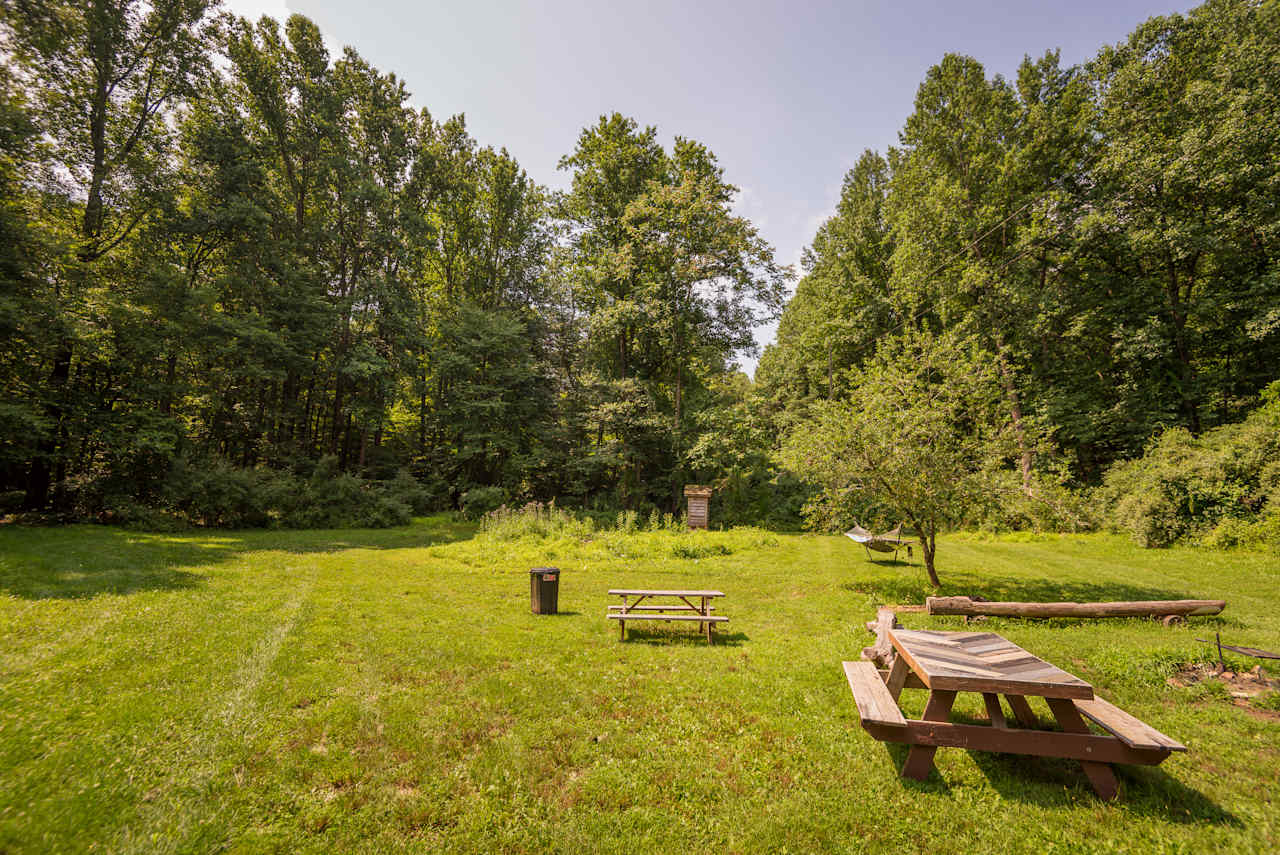 Site #2 is a huge site with a ton of space available for a large group. It has a private outhouse, hammock, firepit, and entrance into the woods for hiking.