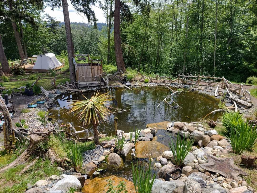 Tent and outdoor shower from bridge over pond