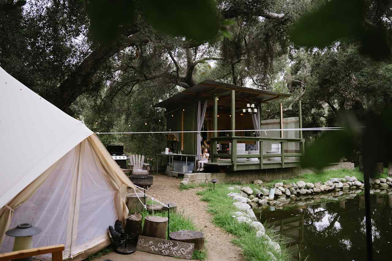 view of the glampsite with the bell tent, firepit, outdoor kitchen and living room 