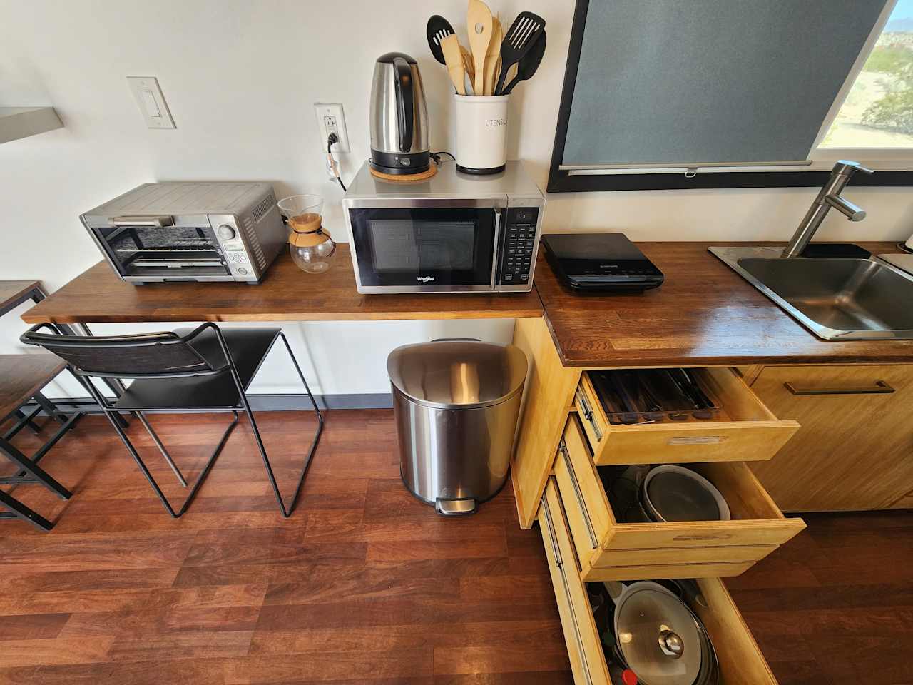 Complete kitchen amenities: microwave, toaster oven, induction cooktop, water boiler, coffee maker, utensils, pots, pans, plates, etc.