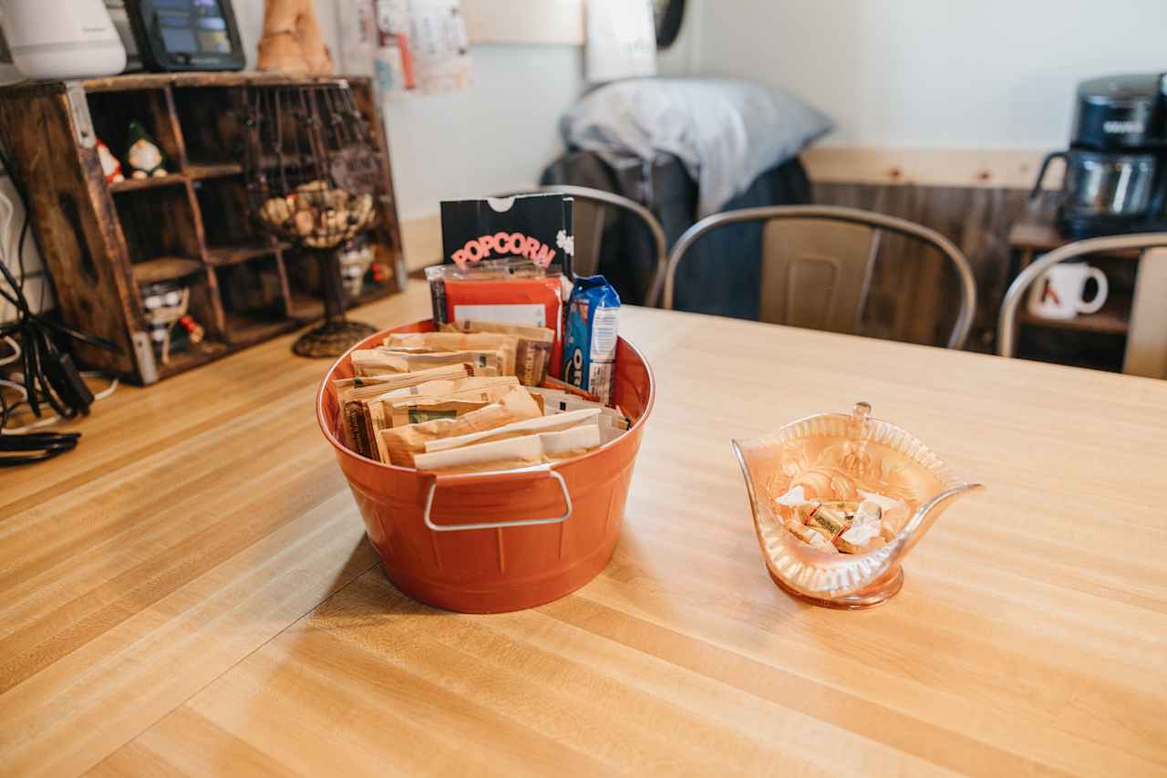 A little basket with treats including cookies, popcorn, oatmeal and teas. 