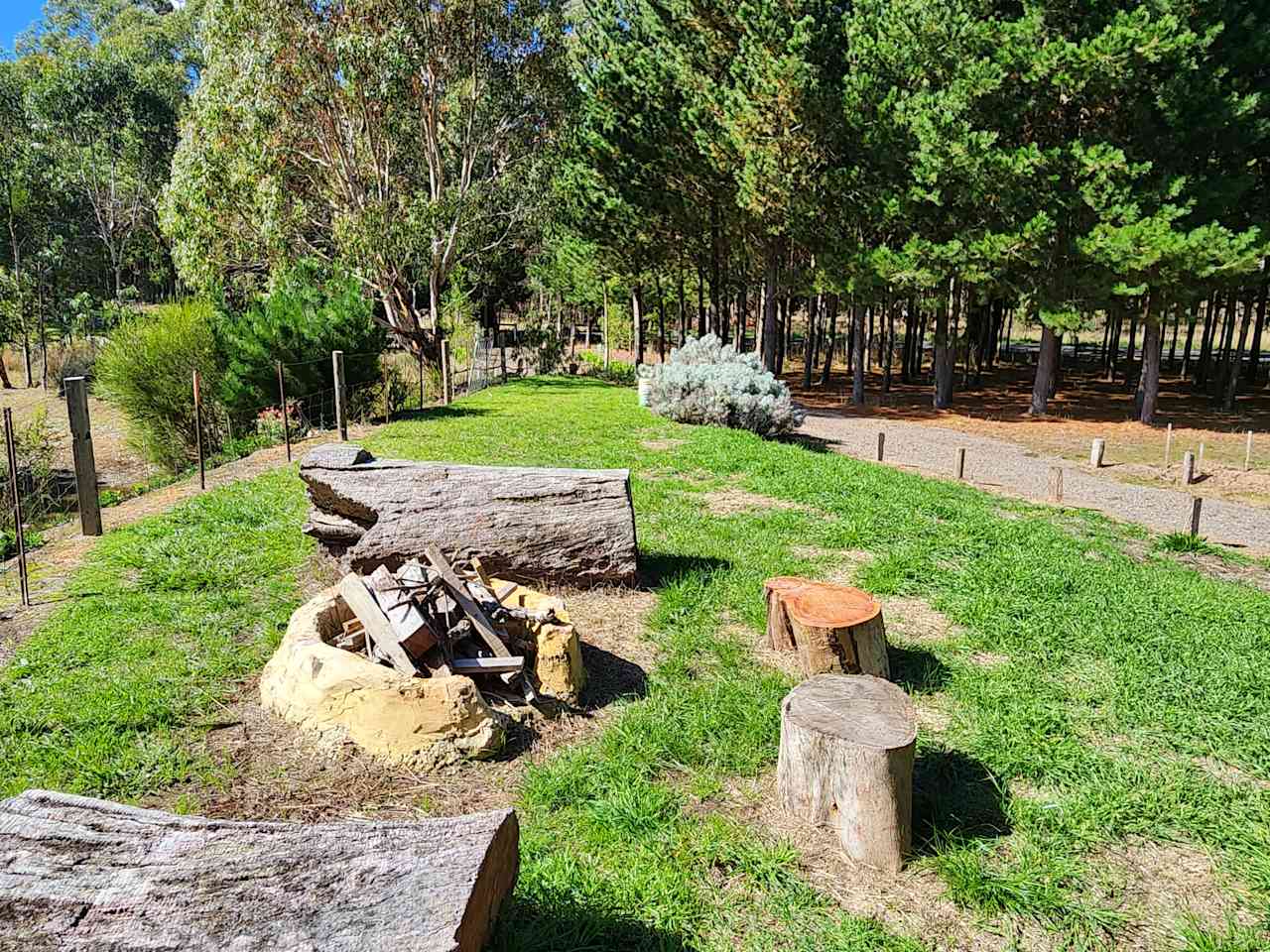 A communal fire pit sits on a ridge, overlooking the dam. Summer, 2024. Forest Gate Winter Wetlands, Kuitpo, SA.