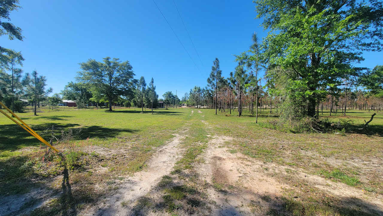 Entrance from gate. RV spots and open camping on the left. Camping in the trees on the right.