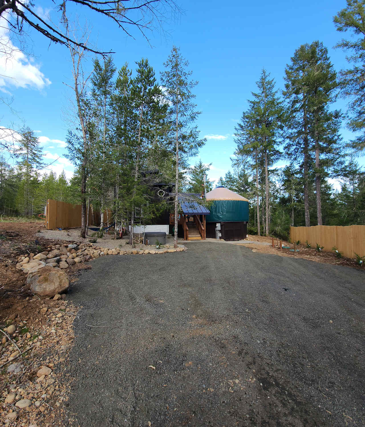 Yurt and cabin view driving up to back of the property. Plenty of parking space, lots of woods! Covered entry!!