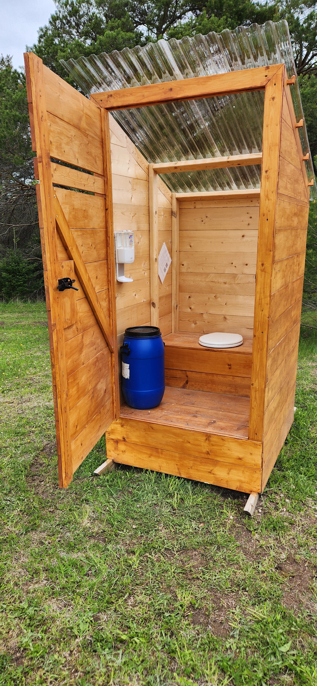 Interior of composting outhouse. Blue barrel holds the sawdust.