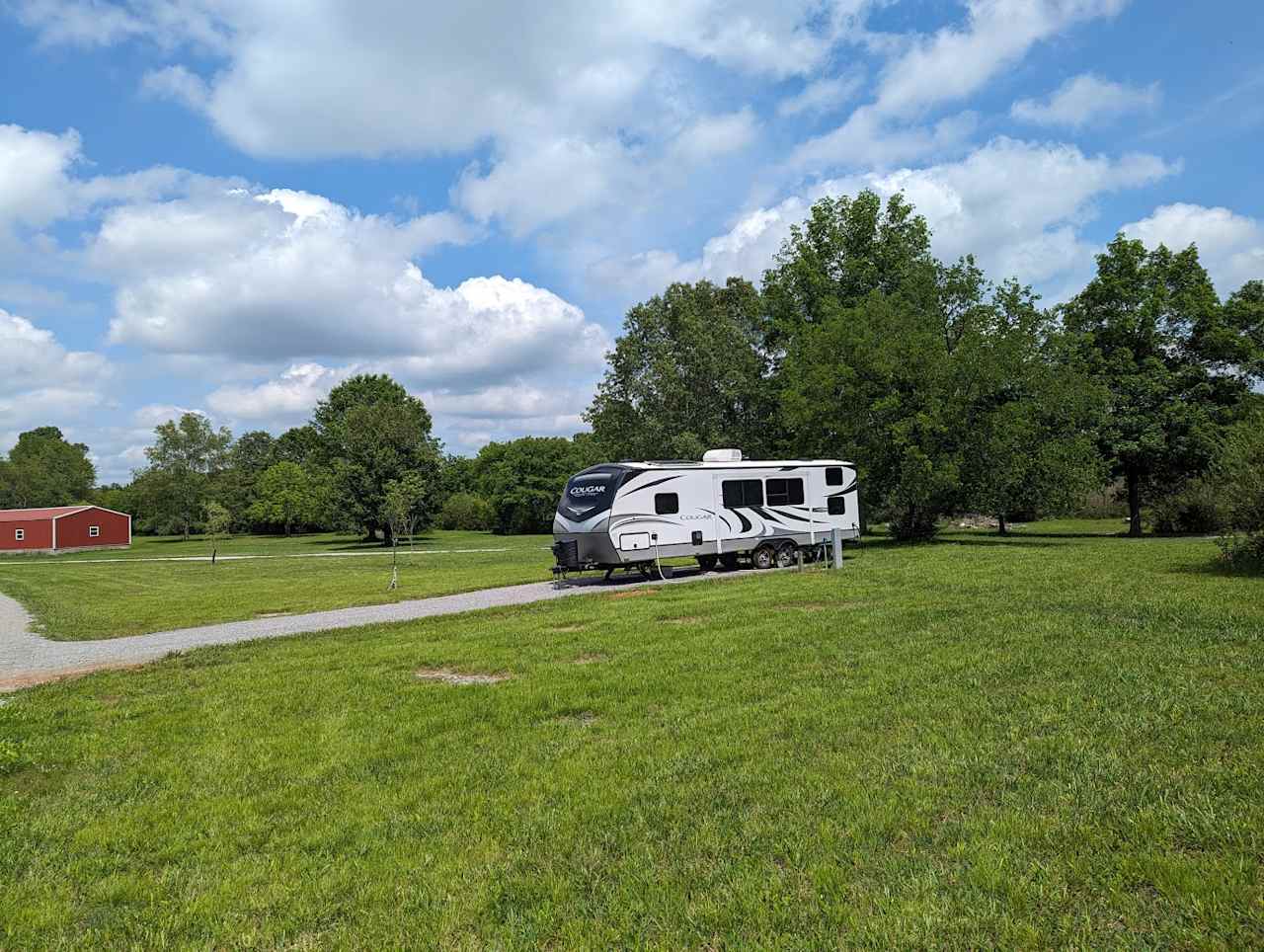 Northeast facing view showing a 34' trailer backed in and hooked up to the electric and water. The slide-out is shown closed, but there's plenty of room for slide-outs on either side!