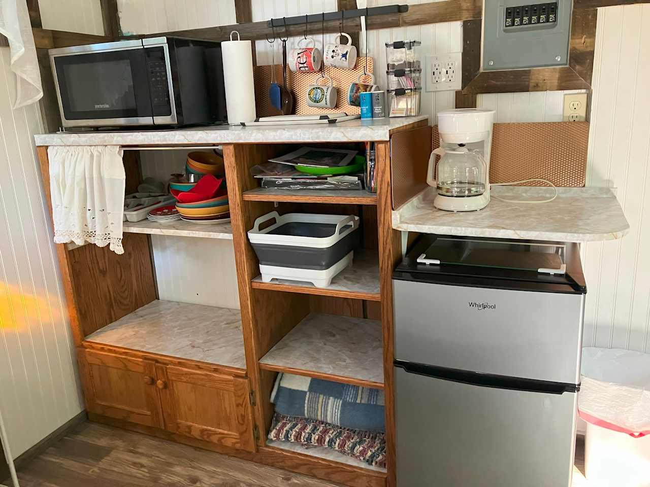 Mini Fridge w Freezer.  New Microwave and Coffee Maker. Pans, Dishes, Cutlery, Cups/Glasses.  Coffee and filters, sugar, creamer, salt/pepper provided