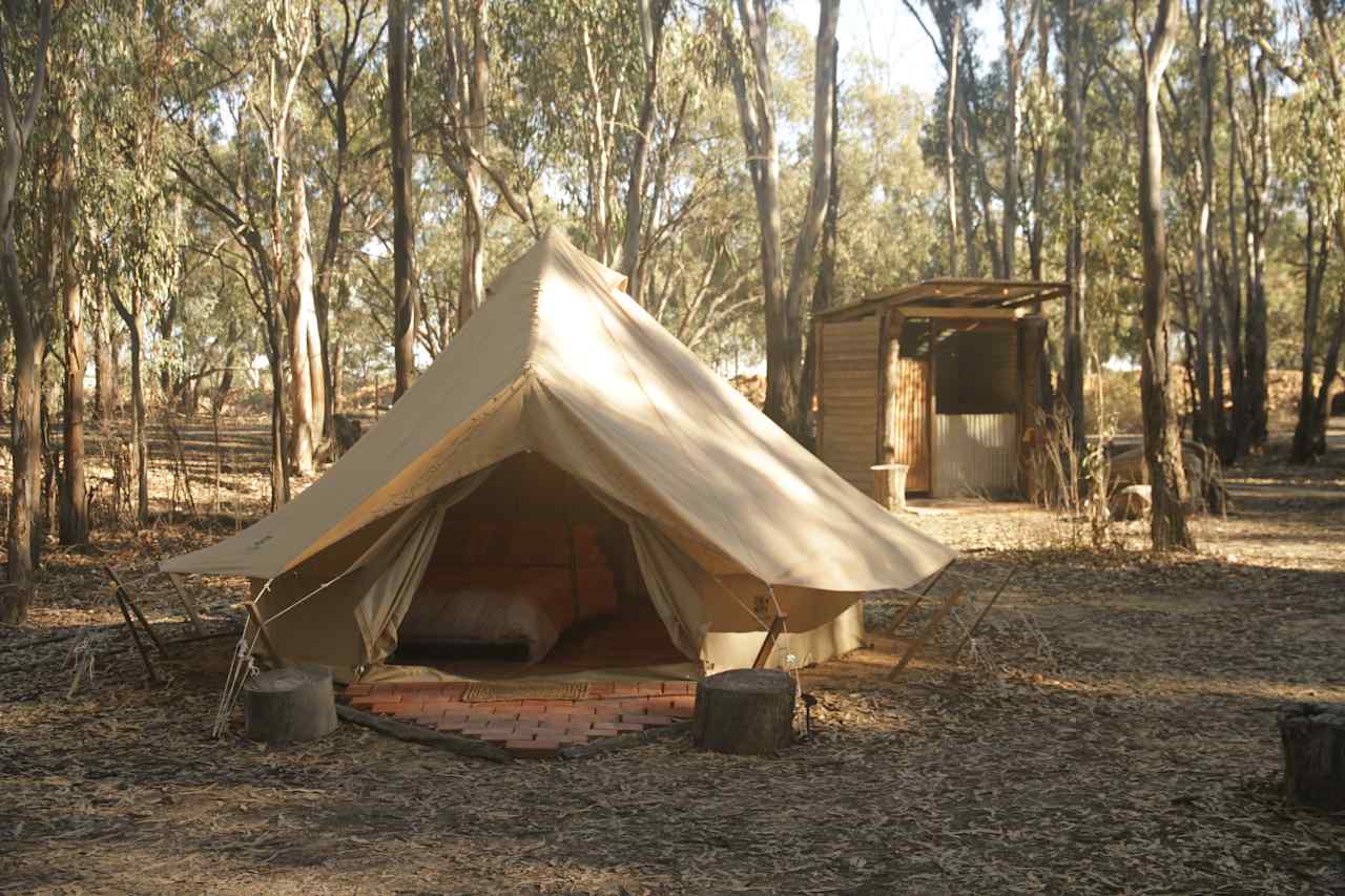 Little Bell glamping tent and private toilet/shower building in the background