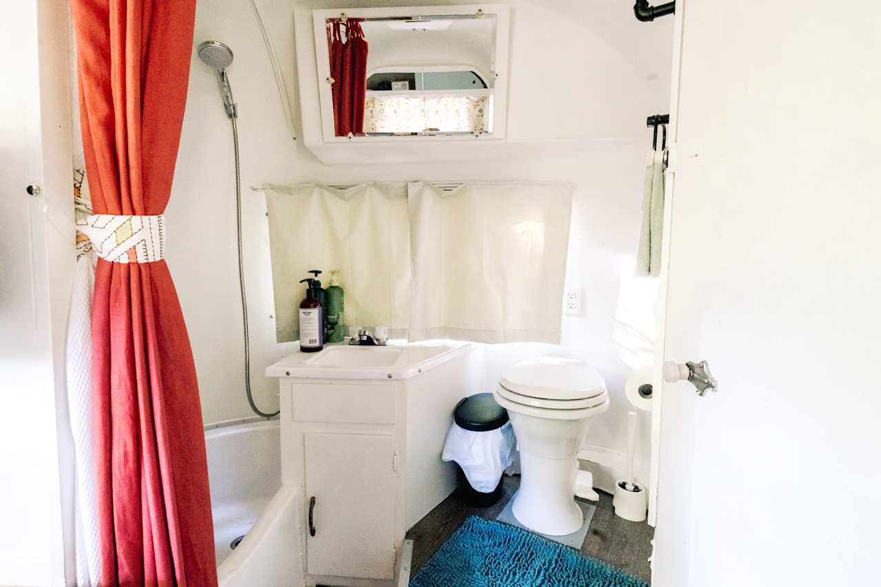 Inside the airstream is a bathroom with toilet, sink, and shower. 