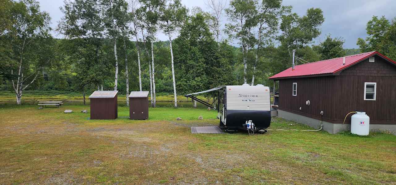 Site 5 has sewer hookup next to the cabin.  The electrical connection is on the side of the cabin.  Your RV can be parked parallel to the cabin (as depicted in the photo) or backed in perpendicular to the cabin.  