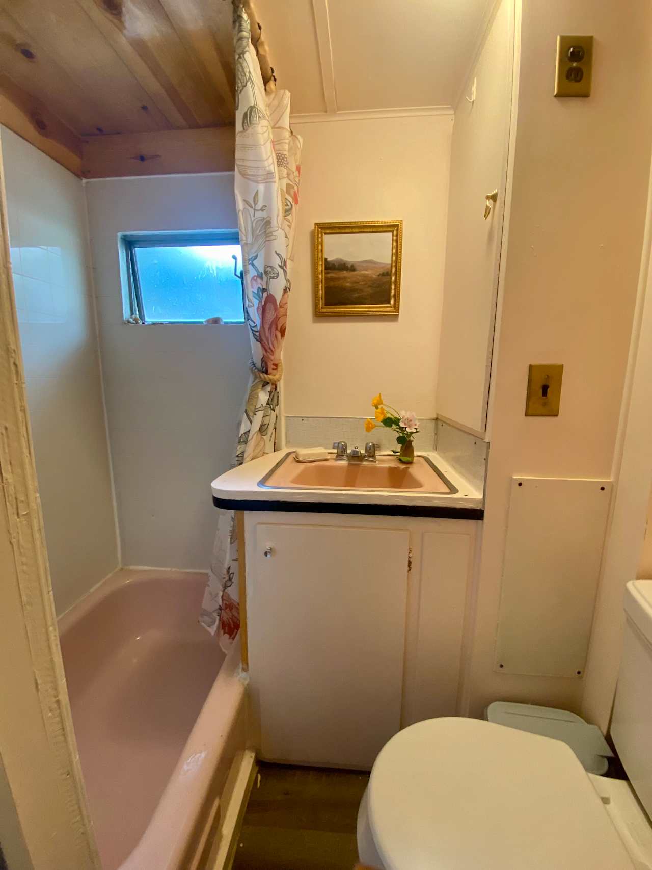 The bathroom is petite…it’s downright small, all the way down to its tiny pink bathtub.
You’ll find it stocked with towels and basic supplies.